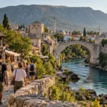 Travelers arriving in Mostar with Stari Most and the Neretva River in the background